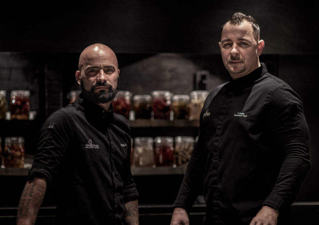 Executive Chef Thomas Huber und Sous-Chef Sergiu Midori posieren in der Gourmetküche des Restaurants Apollo.