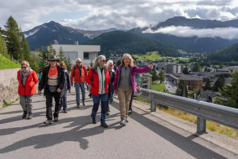 Wandergruppe unterwegs auf einer Strasse oberhalb von Davos