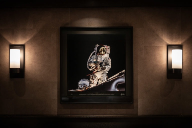 Beleuchtetes Astronautenbild zwischen zwei Wandleuchten im Restaurant Apollo