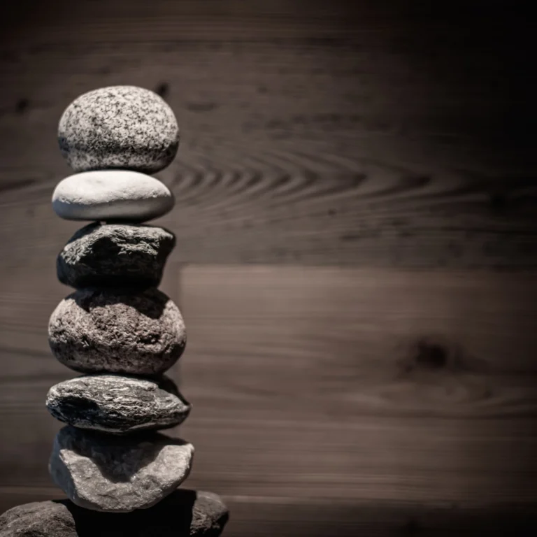 Stacked pebbles on a dark wooden surface