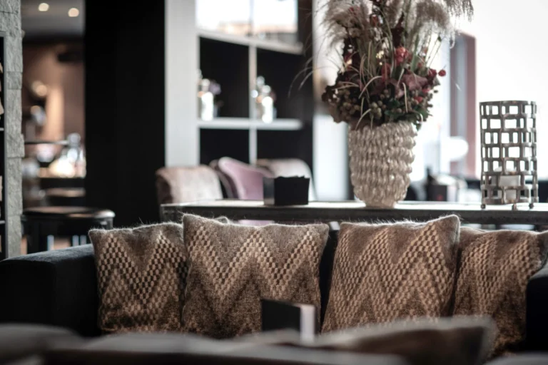 Sitzecke in der Lobby mit gemusterten Kissen und Trockenblumen