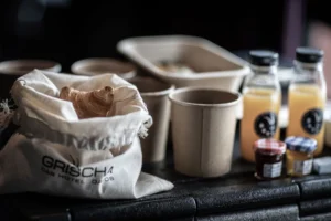 Hotel Grischa brunch box with Gipfeli in a fabric bag, coffee cups and juices