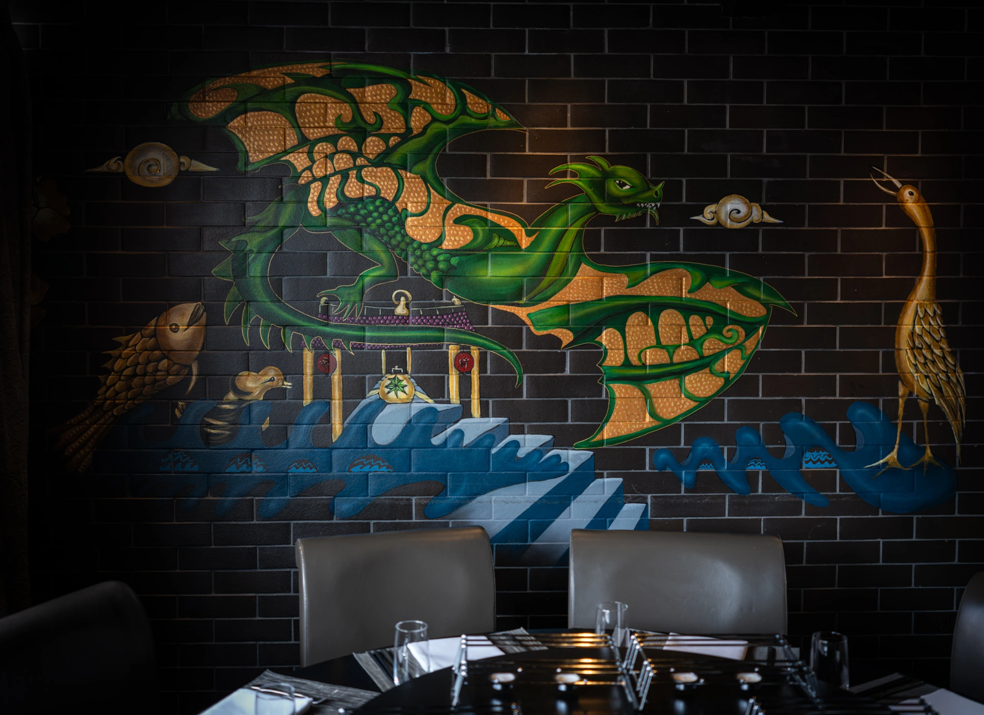 Detailaufnahme einer kunstvollen asiatischen Wandmalerei mit grünem Drachen als Blickfang im stilvollen Restaurantinterieur.