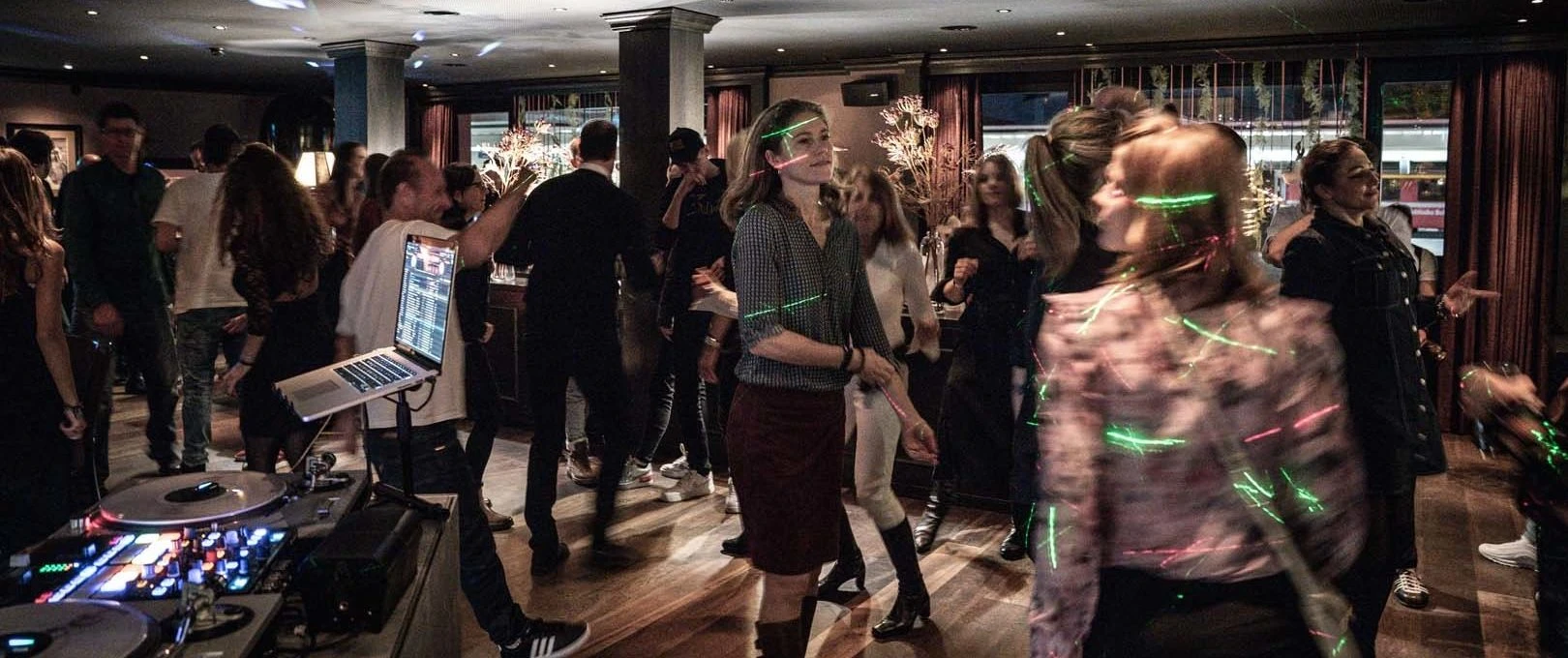 Gäste tanzen an der Jubiläumsfeier vor dem DJ-Pult