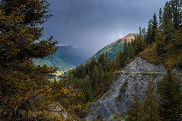 Wooded mountain valley near Davos under dark clouds in autumn
