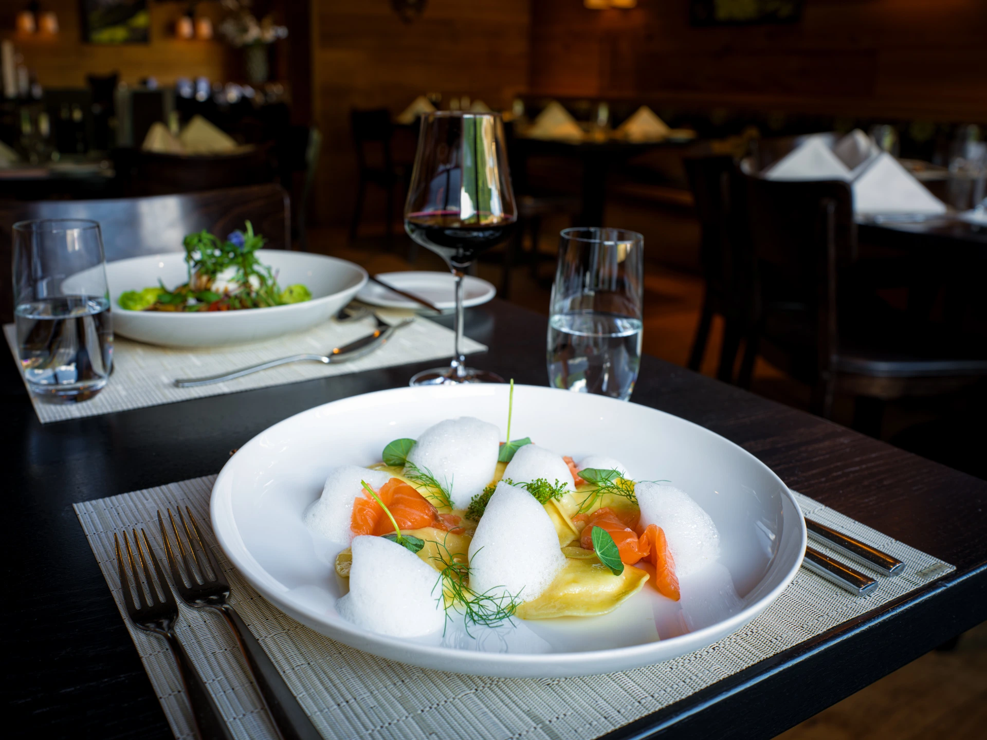 Zitronen-Raviolo mit Lachs, Kräutern und luftigem Schaum als raffinierte Vorspeise im Restaurant Pulsa.