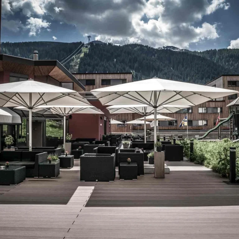 Sun terrace of Hotel Grischa with parasols and lounge furniture