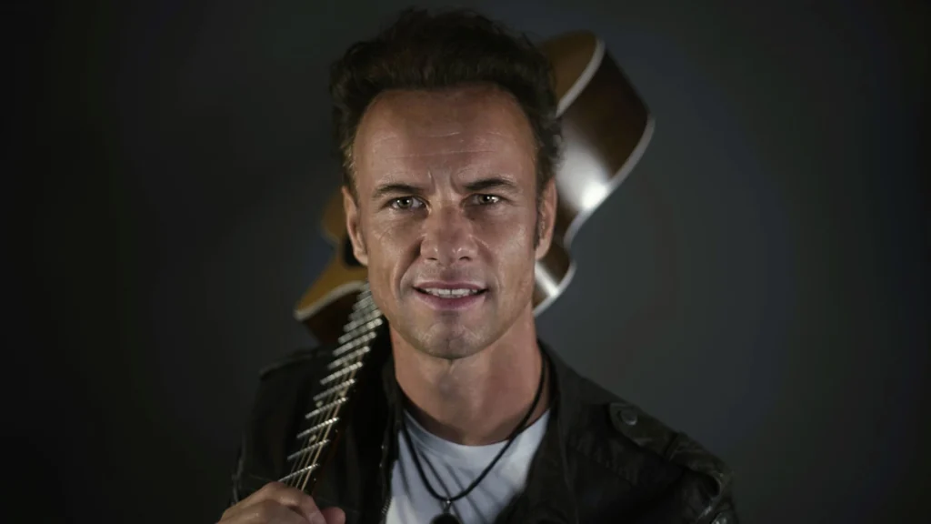 Porträt des Musikers Wolfgang Frank mit Gitarre