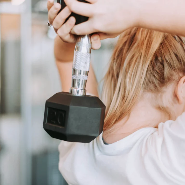 Woman working out in the gym with a dumbbell