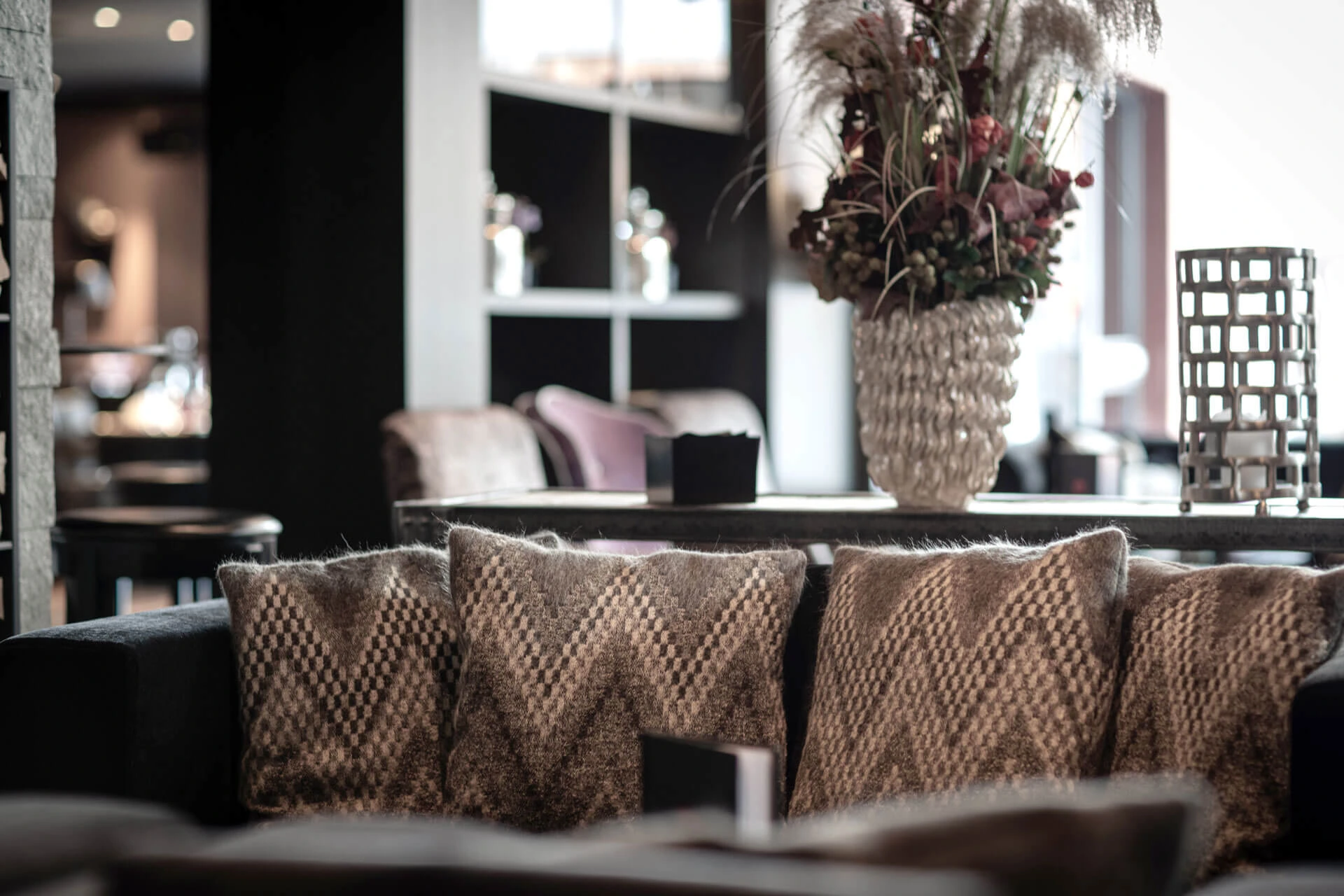 Gemütlicher Lounge-Bereich mit komfortablen Sofas, dekorativen Kissen und stilvoller Einrichtung im Hotel Grischa.