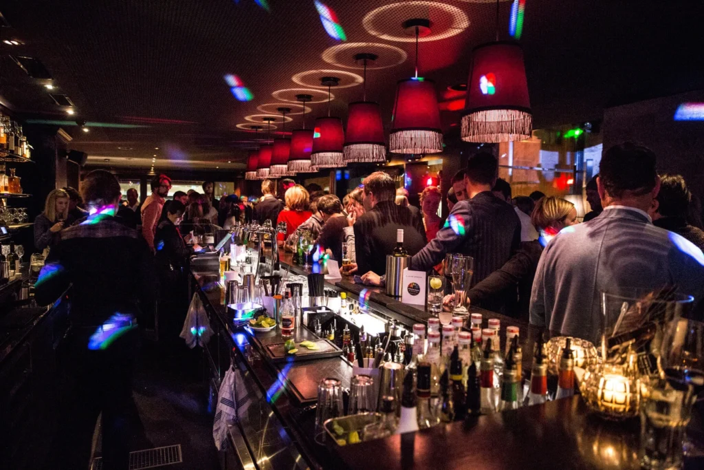 Gäste feiern an der voll besetzten Bar der Pulsa Lounge