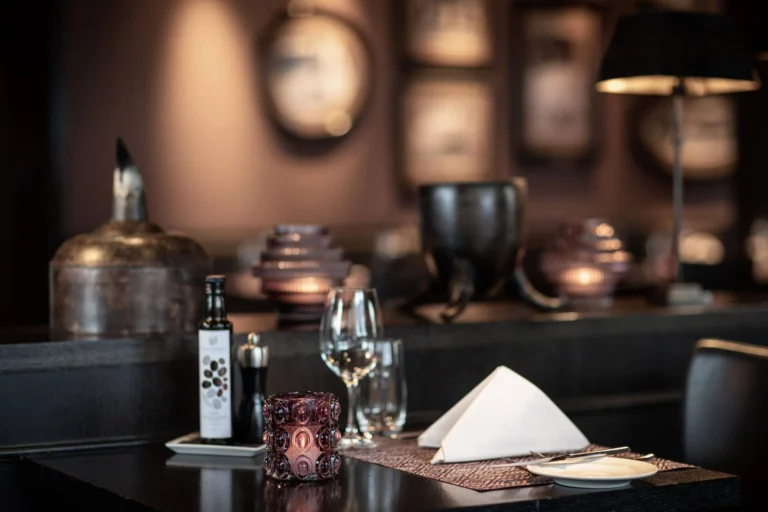 Gedeckter Tisch im Pulsa Restaurant mit Serviette, Weinglas und Olivenölflasche