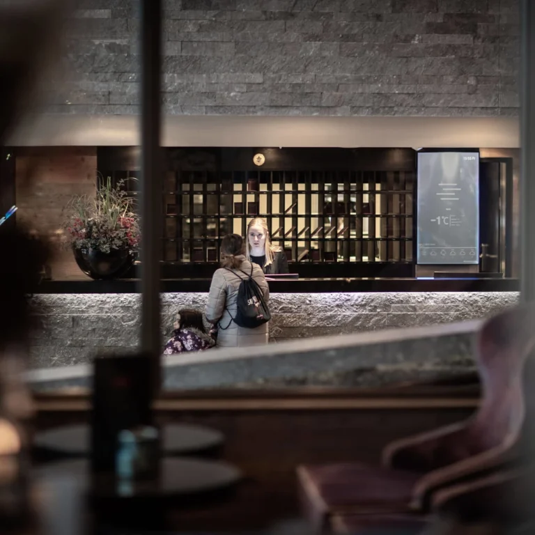 Guest at the reception of Hotel Grischa, view through the window