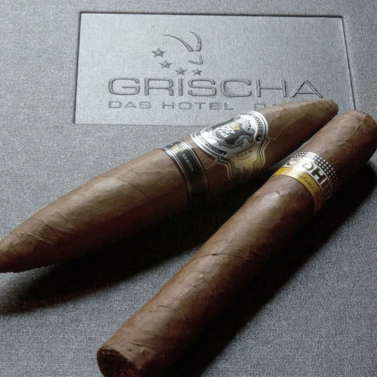 Zwei Zigarren auf einer Schachtel mit Grischa-Logo in der Zino Platinum Cigar Lounge