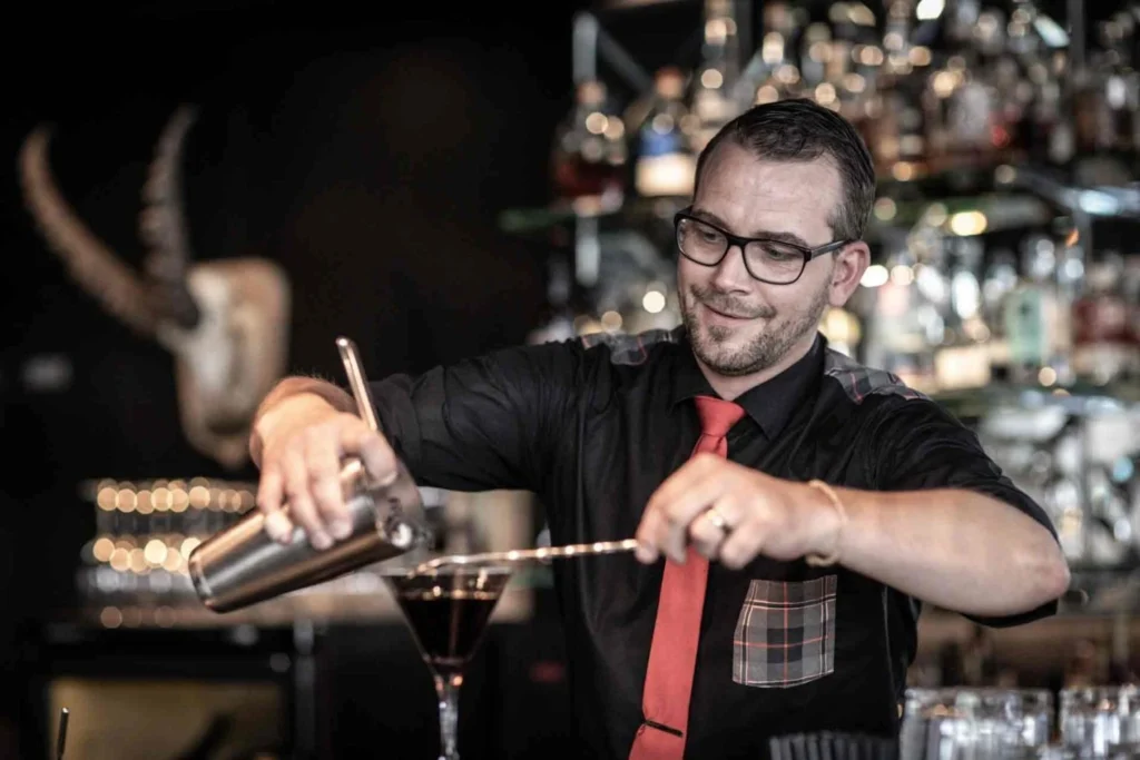 Porträt von Chris beim Zubereiten eines Cocktails an der Bar