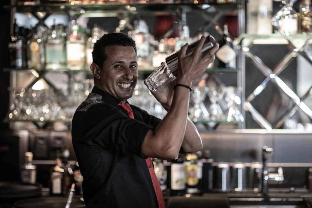 Porträt von Mahmoud mit Cocktailshaker hinter der Bar