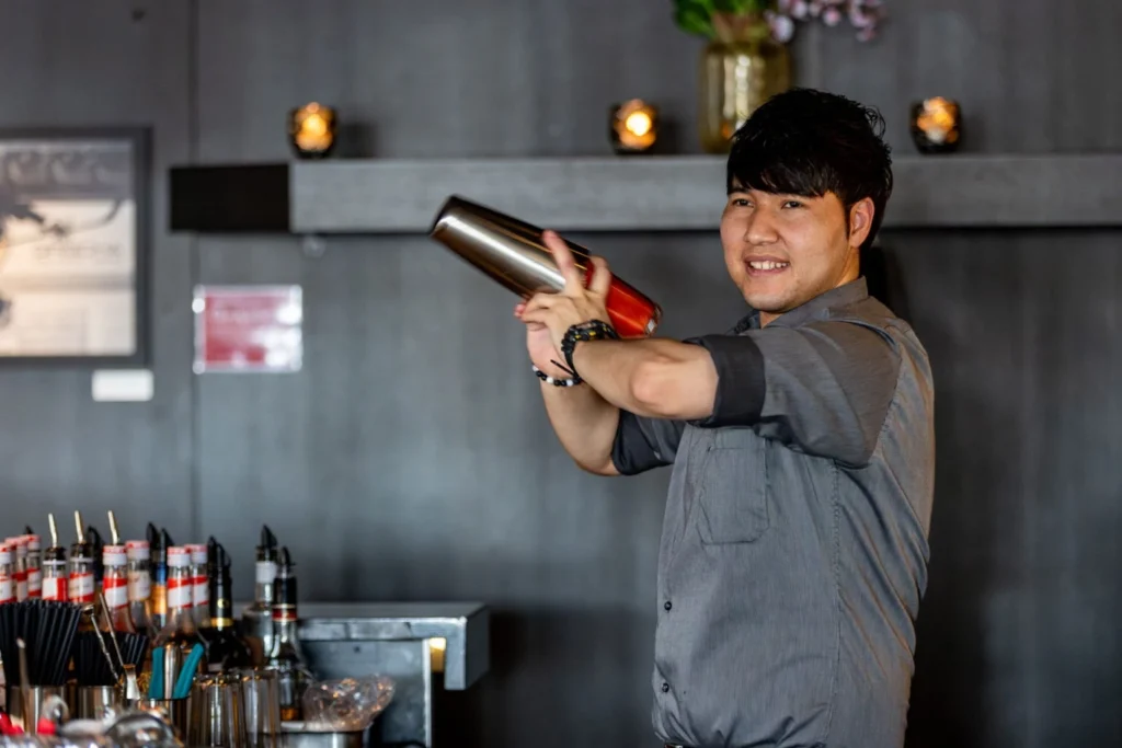 Porträt von Moh mit Cocktailshaker an der Bar