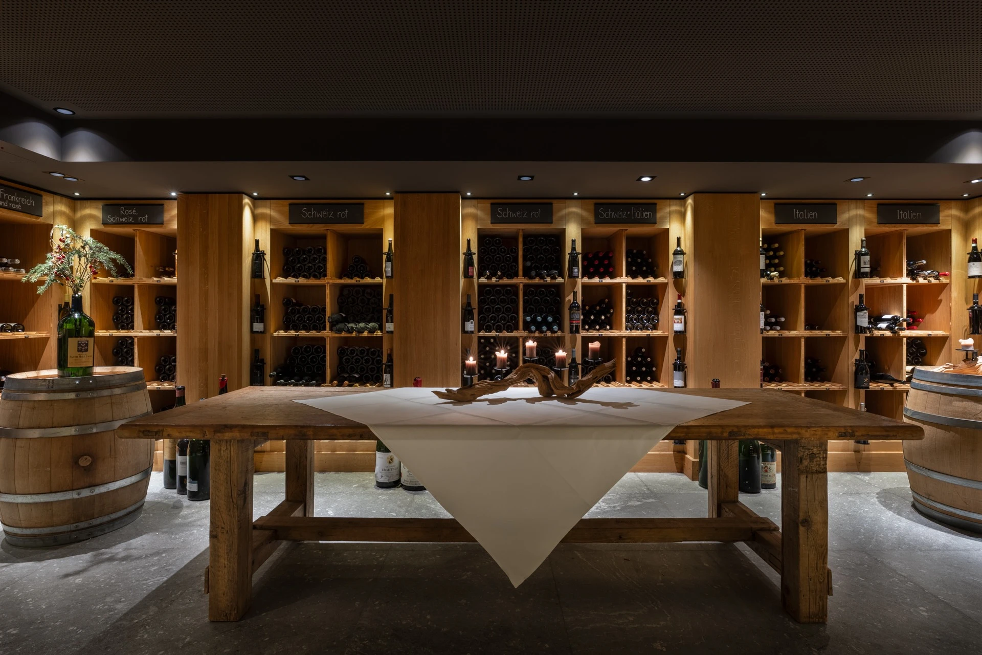 Weinkeller mit langem Holztisch und beleuchteten Weinregalen