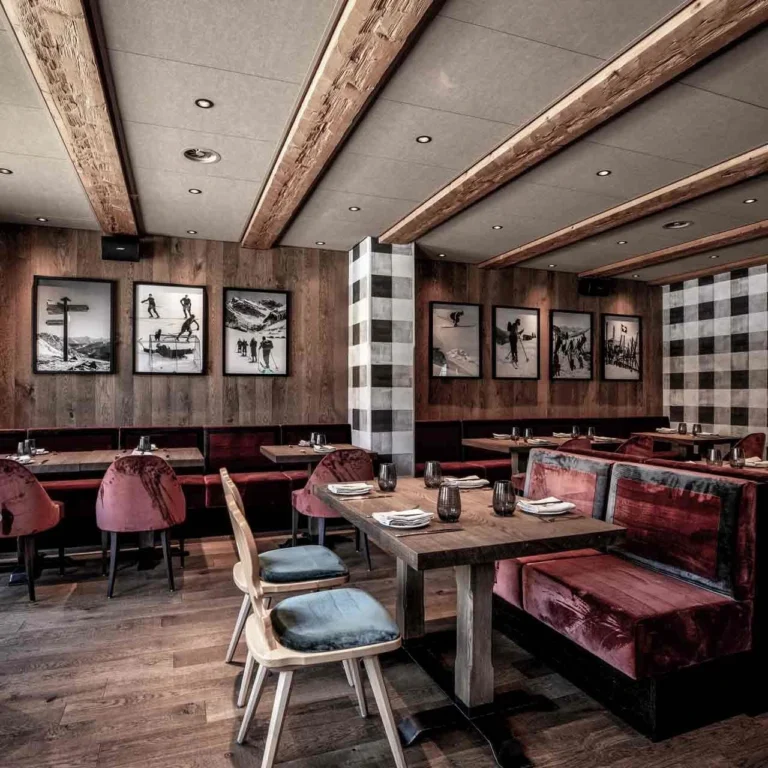 Restaurant Bräma mit Altholzvertäfelung, Karostoffen und Ski-Fotografien an der Wand