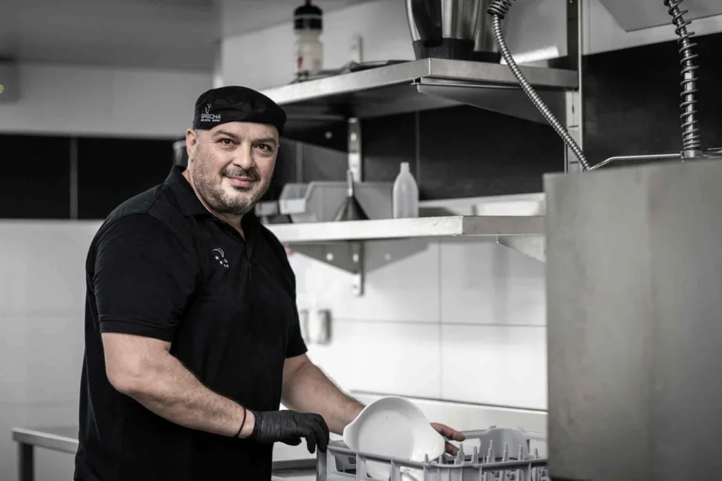 Porträt von Ioannis an der Spülmaschine in der Küche