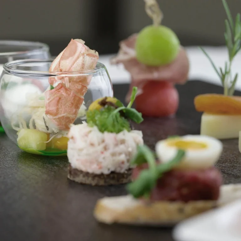 Appetizer bites with tartare, melon, and air-dried ham on a slate plate