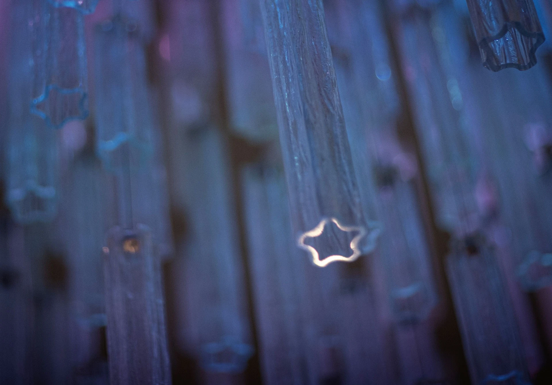 Detailaufnahme des Kristallleuchters mit Sternmotiv in blauem Licht