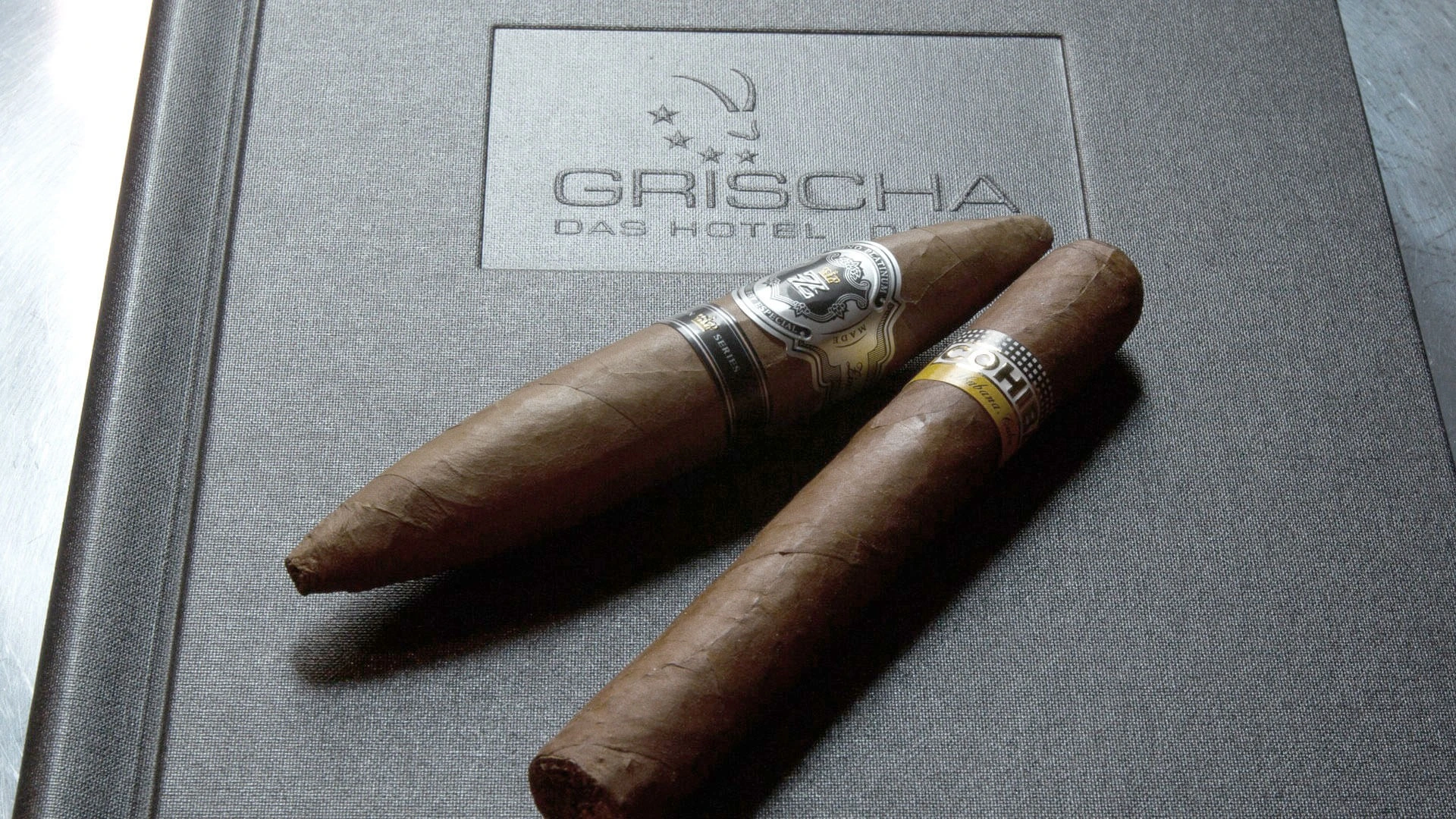 Zwei Zigarren auf einer Schachtel mit Grischa-Logo in der Zino Platinum Cigar Lounge