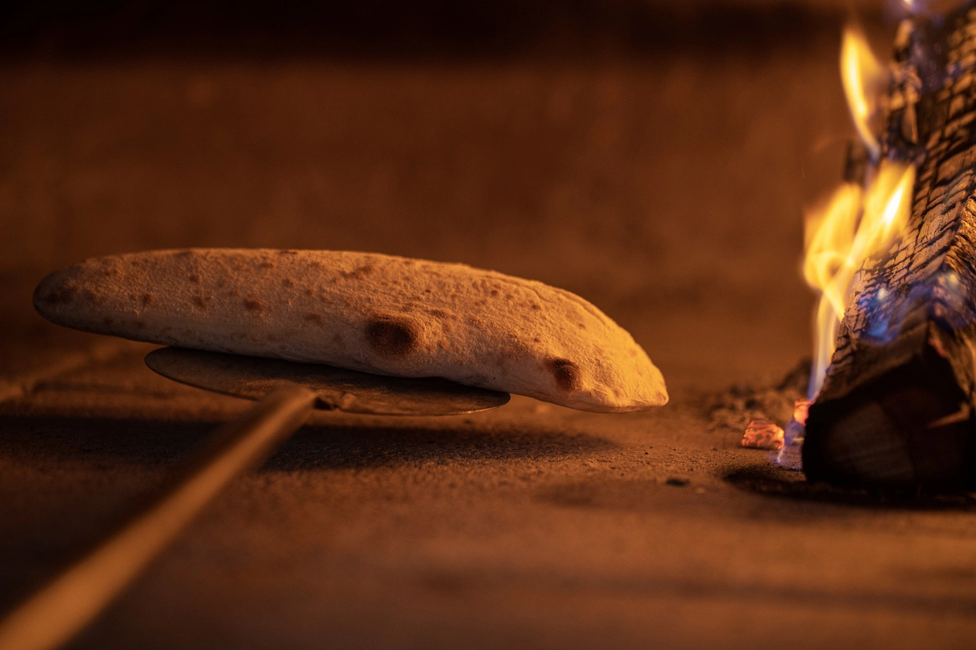 Pizzabrot neben dem Feuer im Pizzaofen.