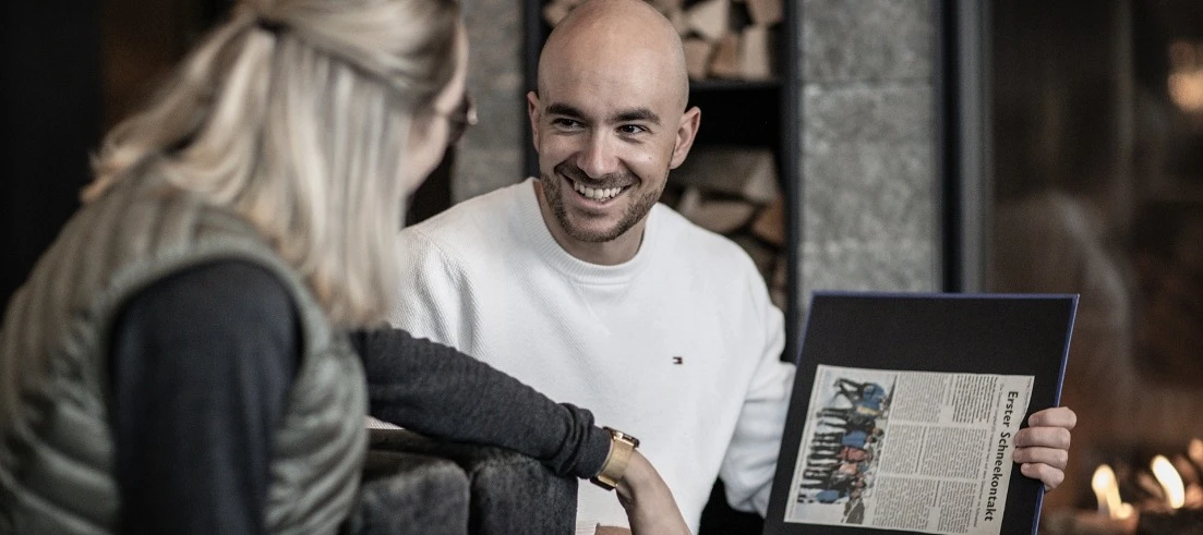 Employee showing a guest a newspaper article