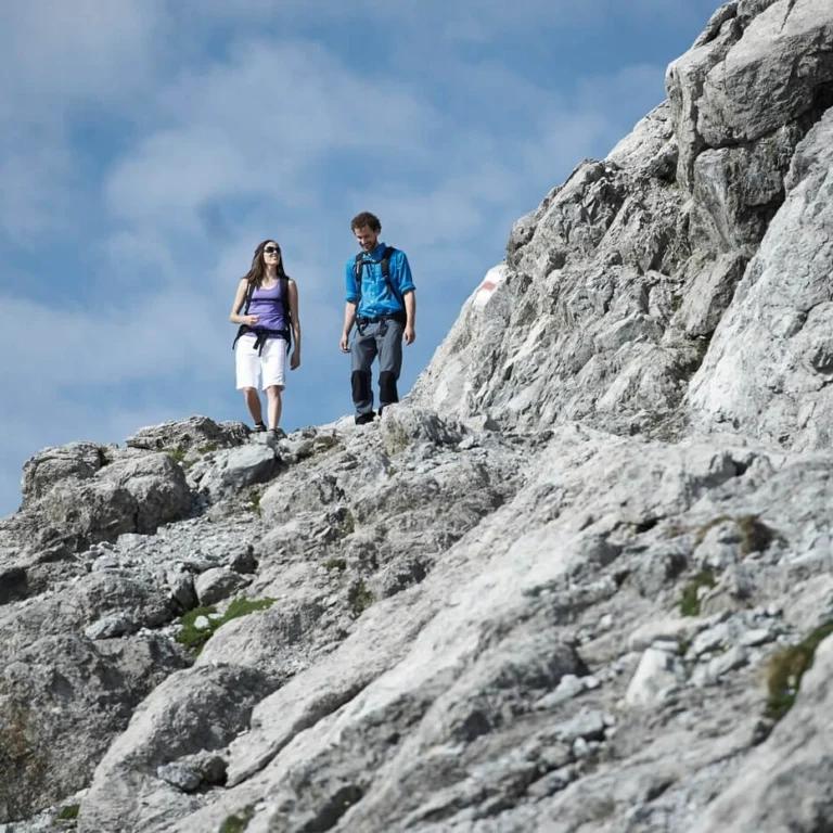 Two hikers on the rocky ridge of the Weissfluh summit near Davos