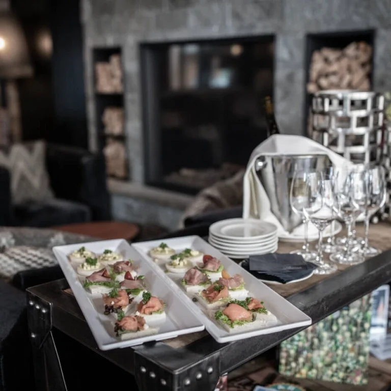 Appetizer platters with snacks and glasses in front of the fireplace