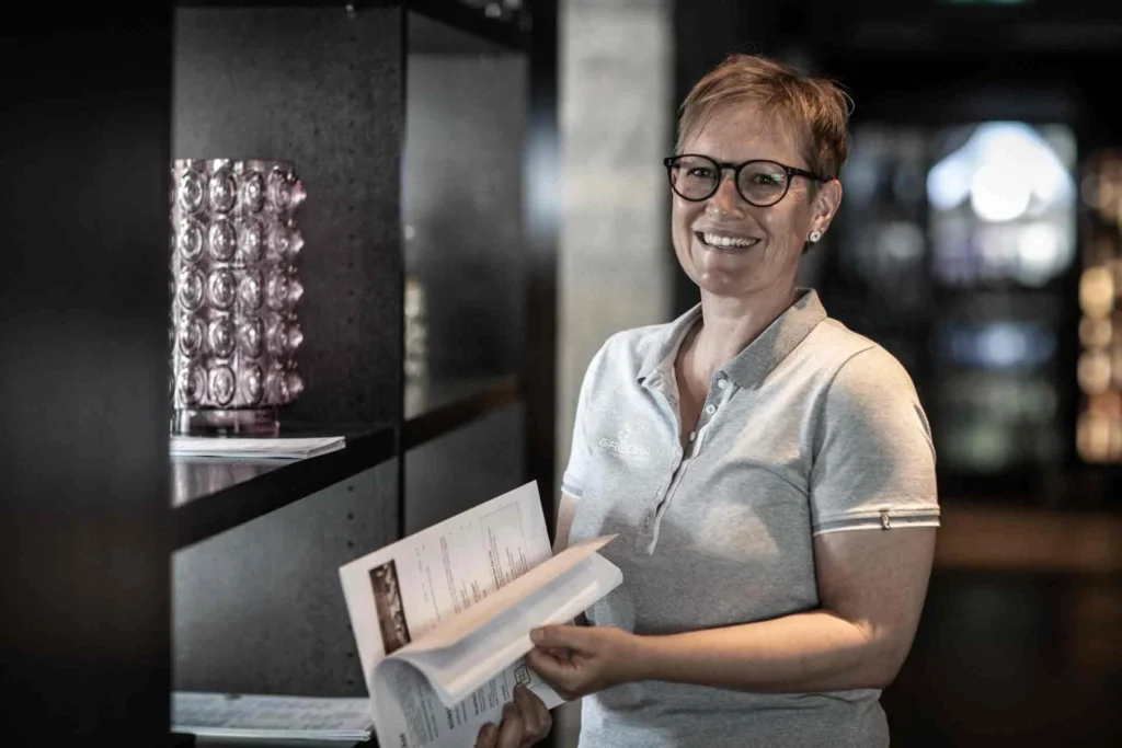 Porträt von Corina mit einer Broschüre in der Lobby